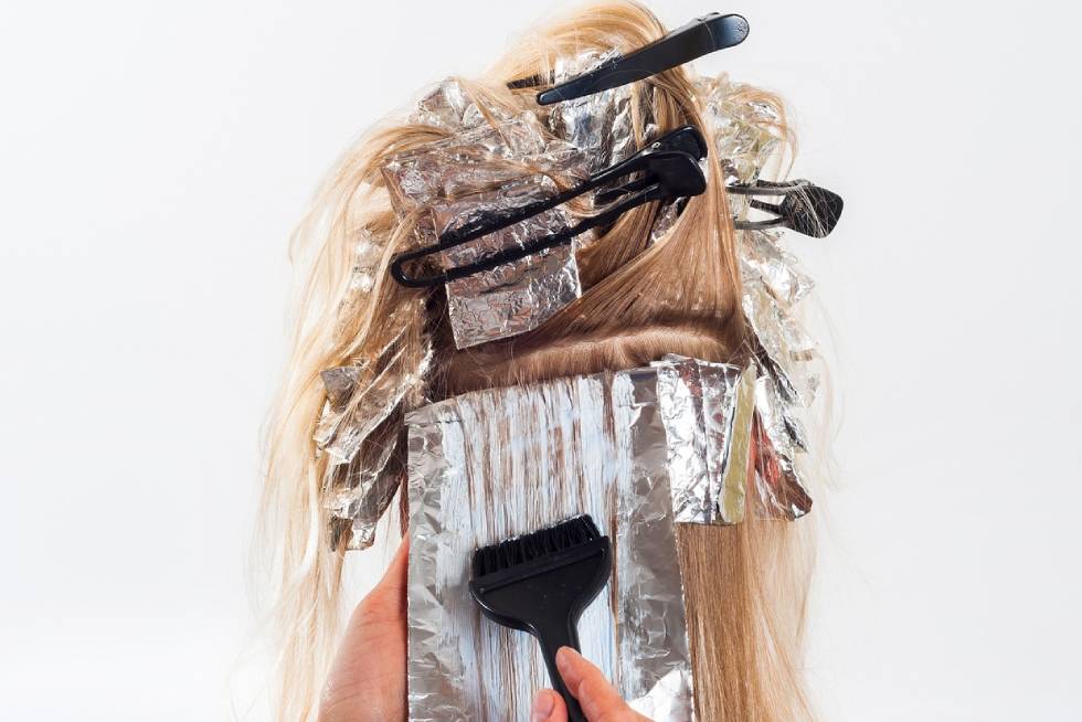 a person colouring hair with foil and hair clips
