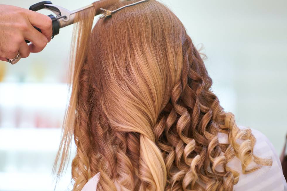 a person styling long curly hair 